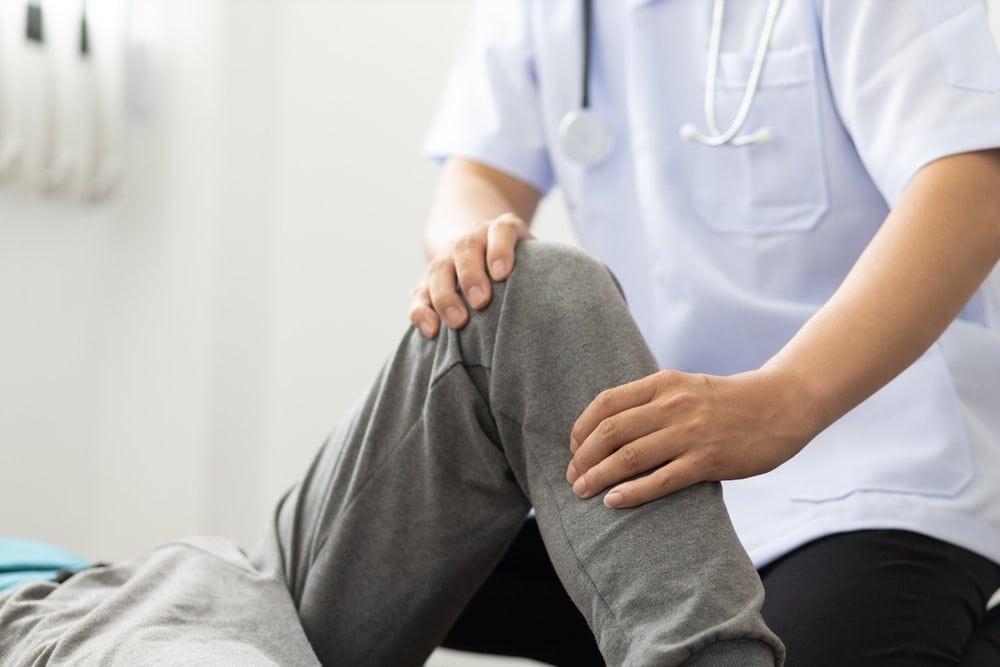 คุณหมอผู้ดูแลกำลังพลิกตัวผู้ป่วยเพื่อป้องกันแผลกดทับ