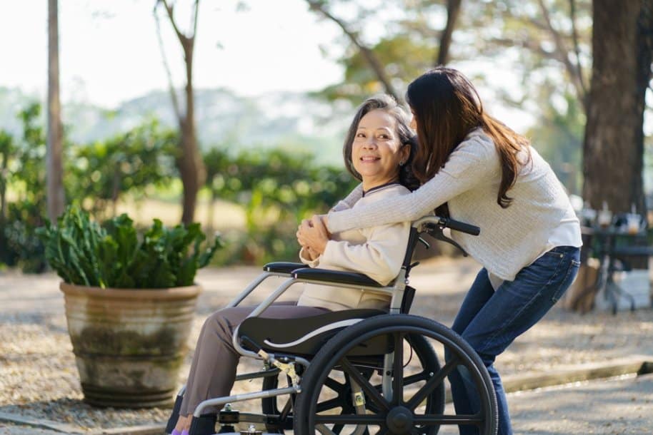 ลูกสาวพาแม่ออกไปนอกบ้านโดยใช้วีลแชร์ผู้สูงอายุ